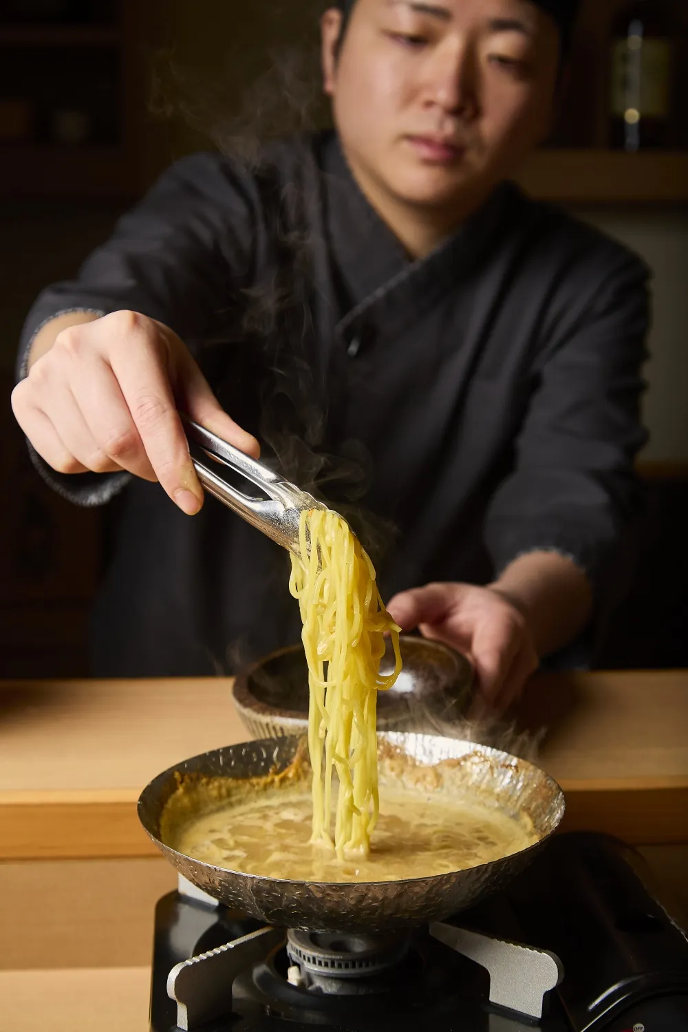 贅沢・雲丹鍋の出汁で締めの麺を仕上げる様子