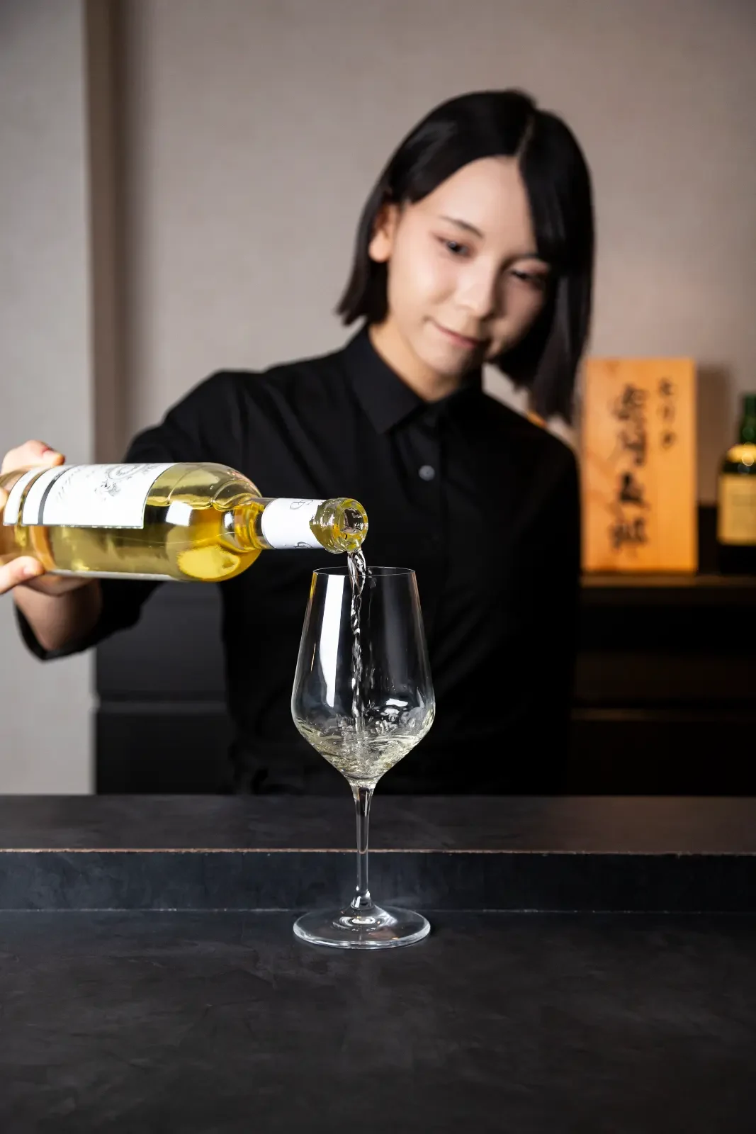 ドリンクの白ワインを注ぐ様子。京都店で撮影