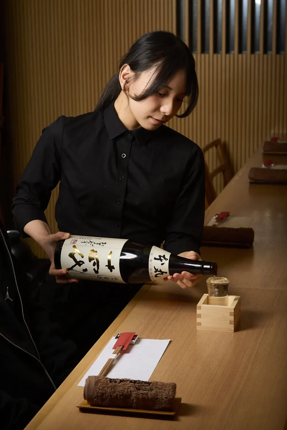 日本酒を紹介するスタッフ。大阪本店で撮影